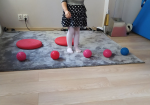 Dziewczynka układa rytm z piłek.